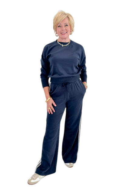 Front view of woman wearing Swagger Boutique’s Eclipse Breakaway Track Pants by Z Supply with Eclipse Comeback Sweatshirt by Z Supply against white studio background.