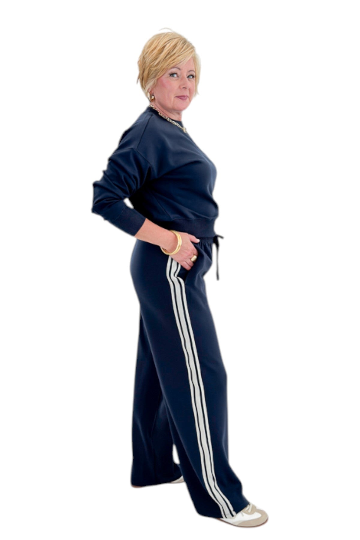 Side view of woman wearing Swagger Boutique’s Eclipse Breakaway Track Pants by Z Supply with Eclipse Comeback Sweatshirt by Z Supply against white studio background.