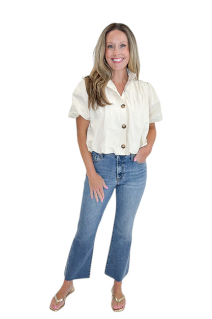 Front view of woman wearing Swagger Boutique’s Ecru Bubble Hem Button Up Top by Entro with jeans against white studio background.