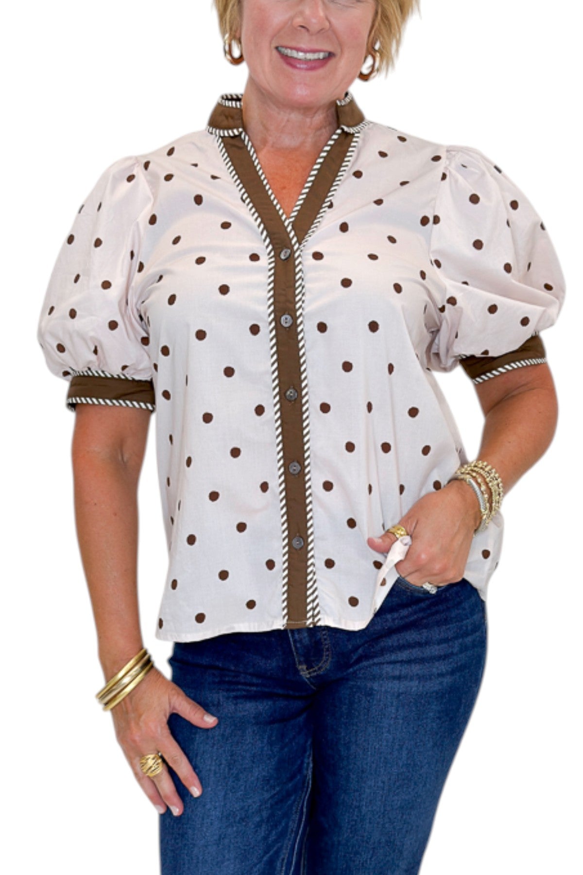 Front detail view of woman wearing Swagger Boutique’s Ecru &amp; Brown Polka Dot Button Up Top by Entro with jeans against white studio background.