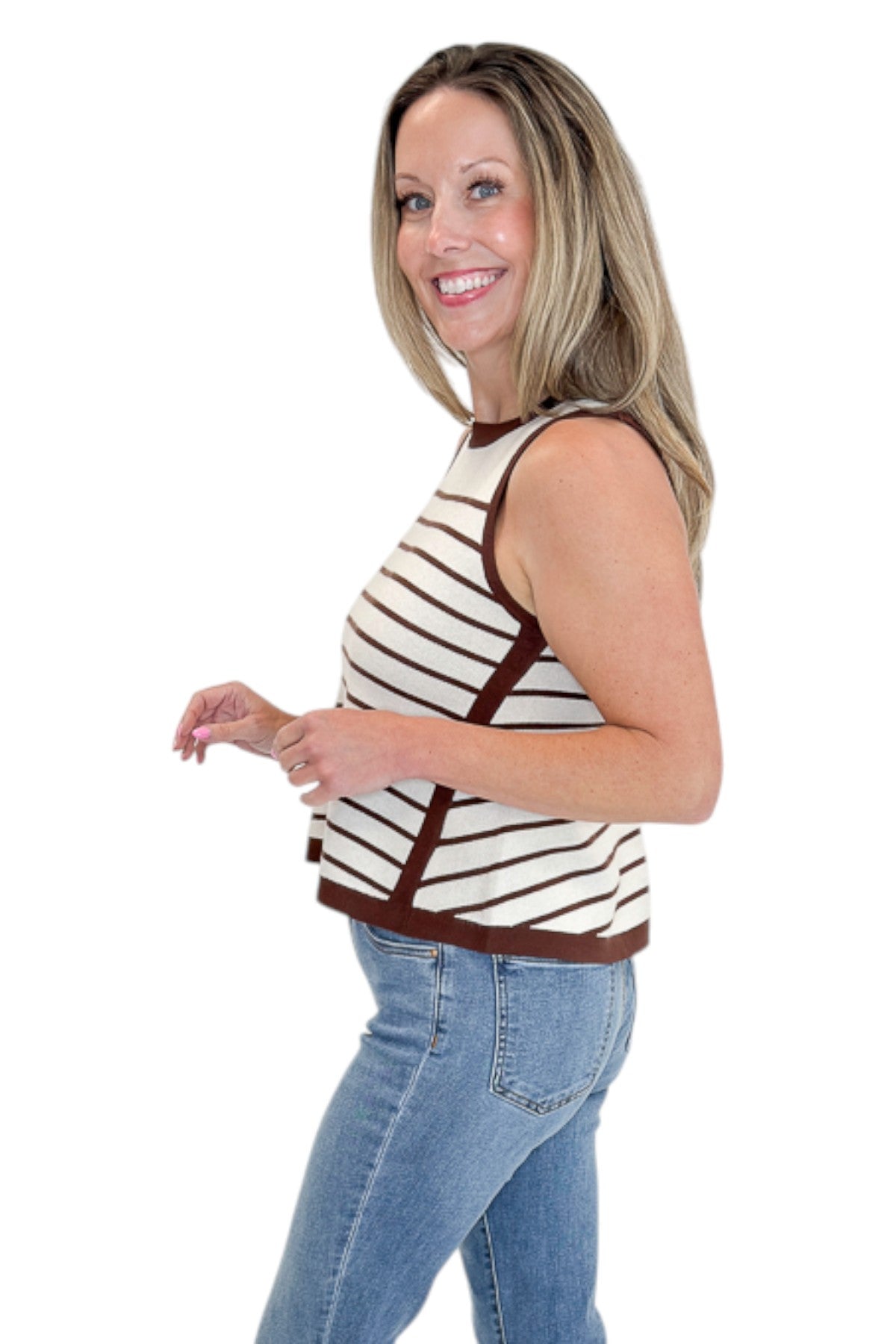 Side view of woman wearing Swagger Boutique’s Ecru &amp; Brown Striped Tank with jeans against white studio background.