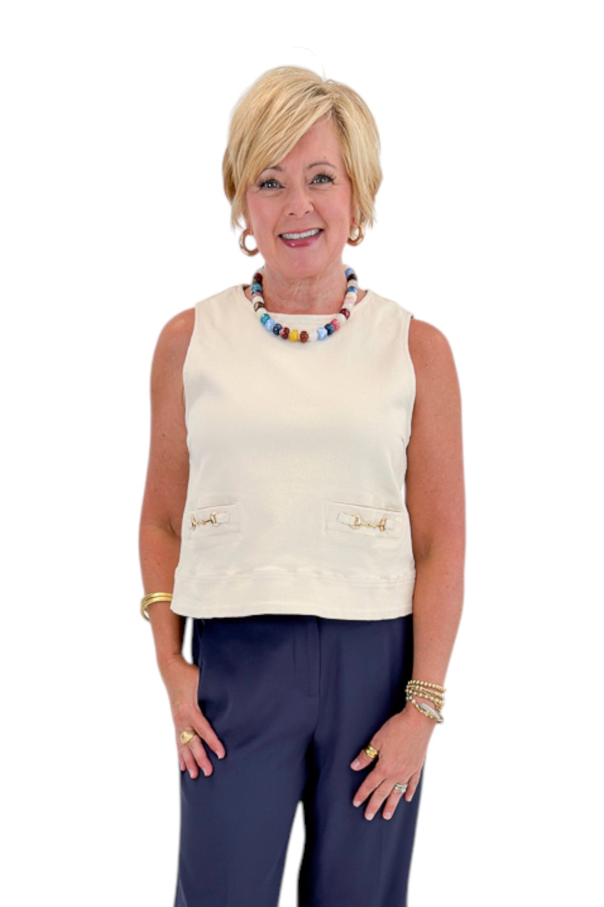 Front view of woman wearing Swagger Boutique’s Ecru Horsebit Buckle Tank by Entro with Navy High Waisted Trousers by Skies Are Blue against white studio background.