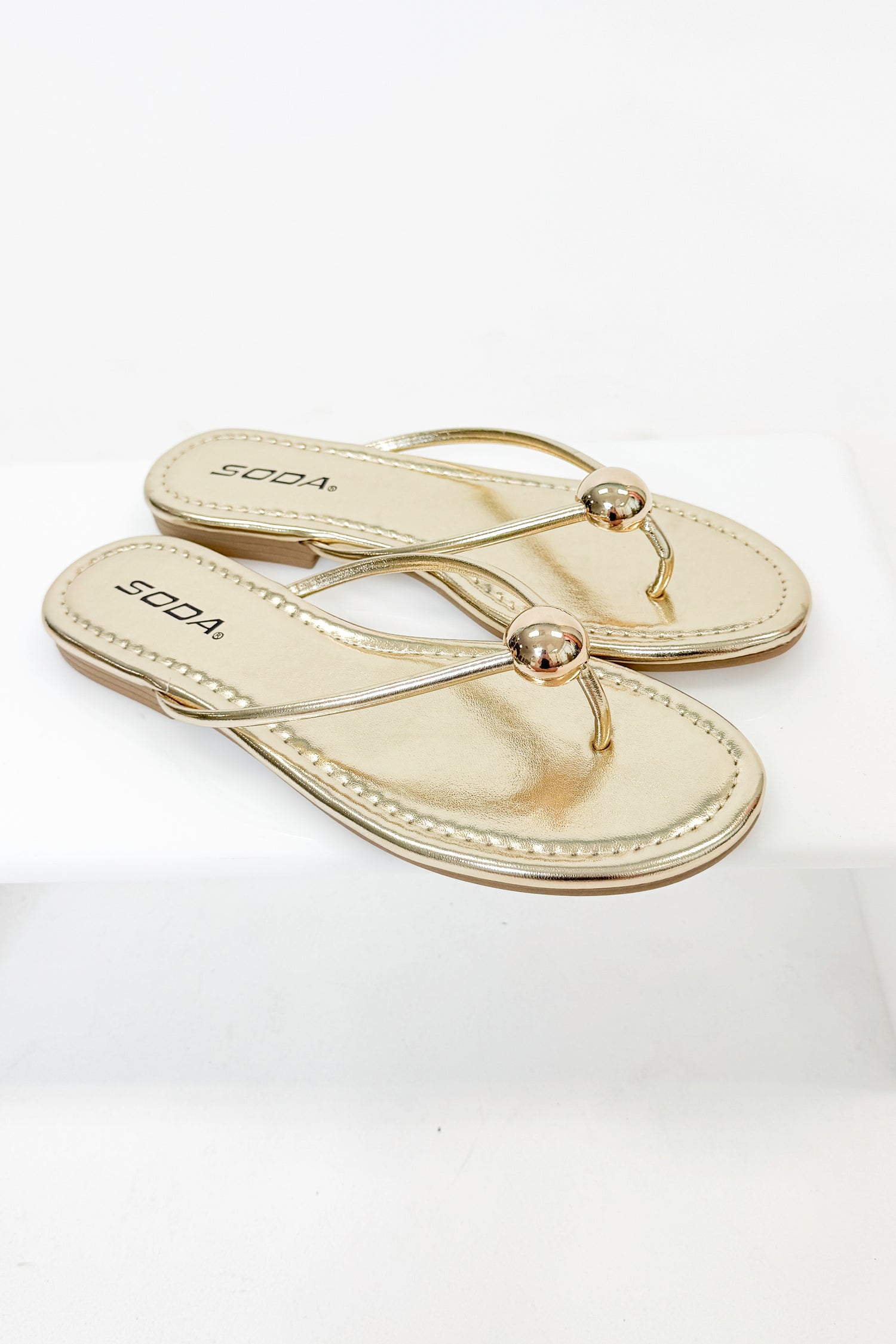 Elwood- Gold Ball Flip Flop against white studio background
