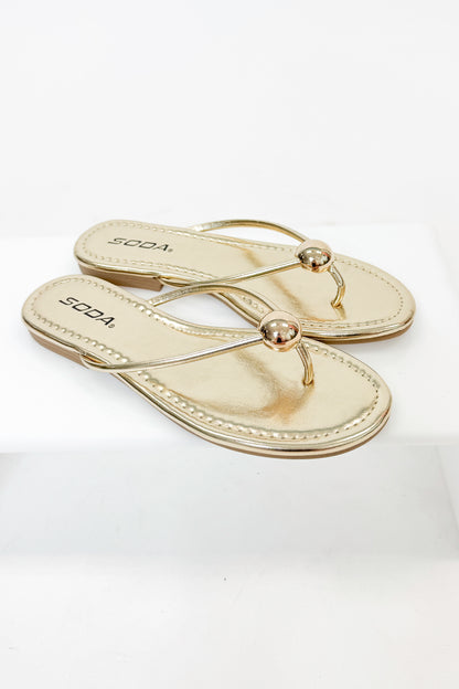 Elwood- Gold Ball Flip Flop against white studio background