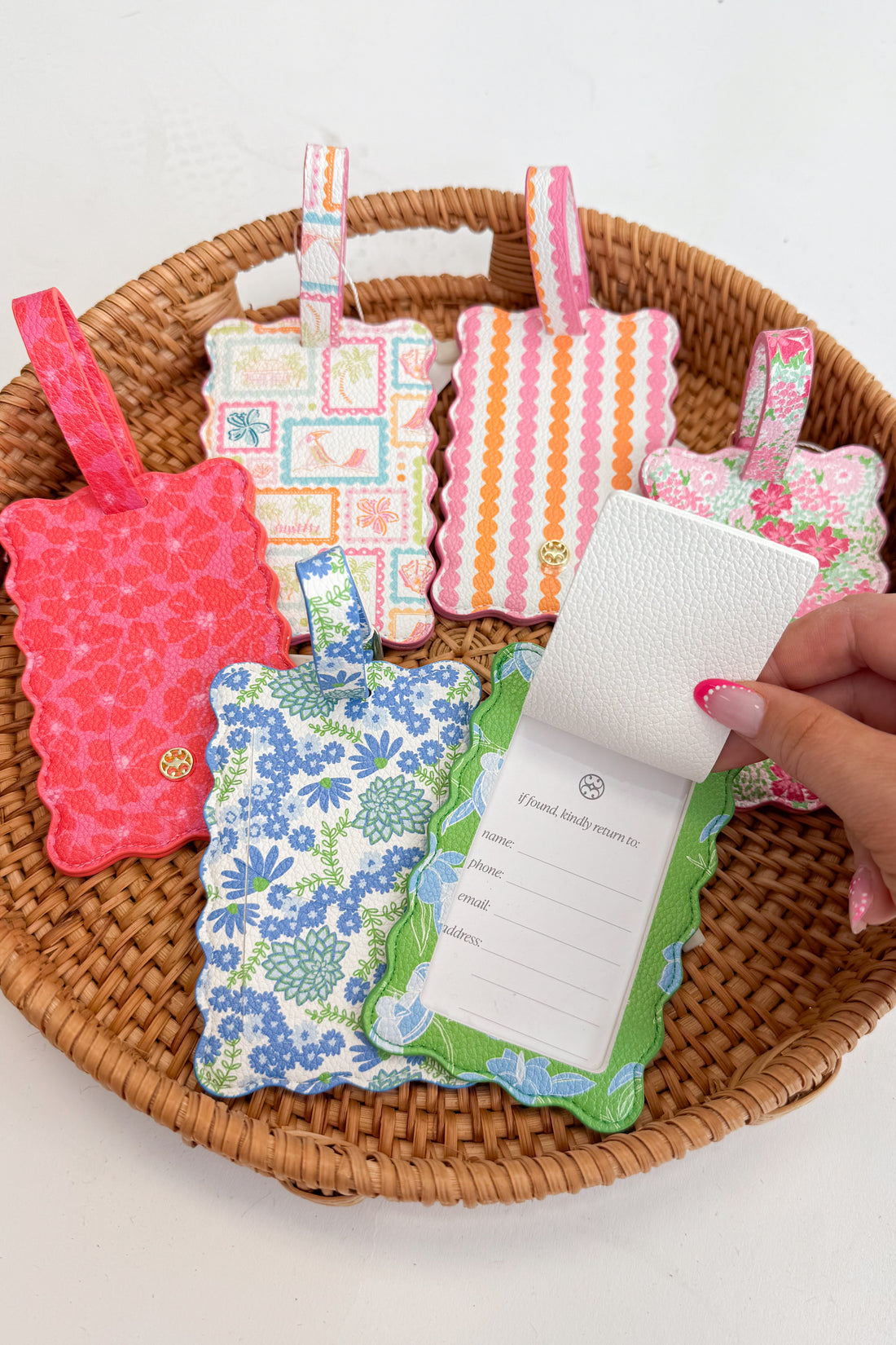Colorful fabric tags in a woven basket with a hand holding one.