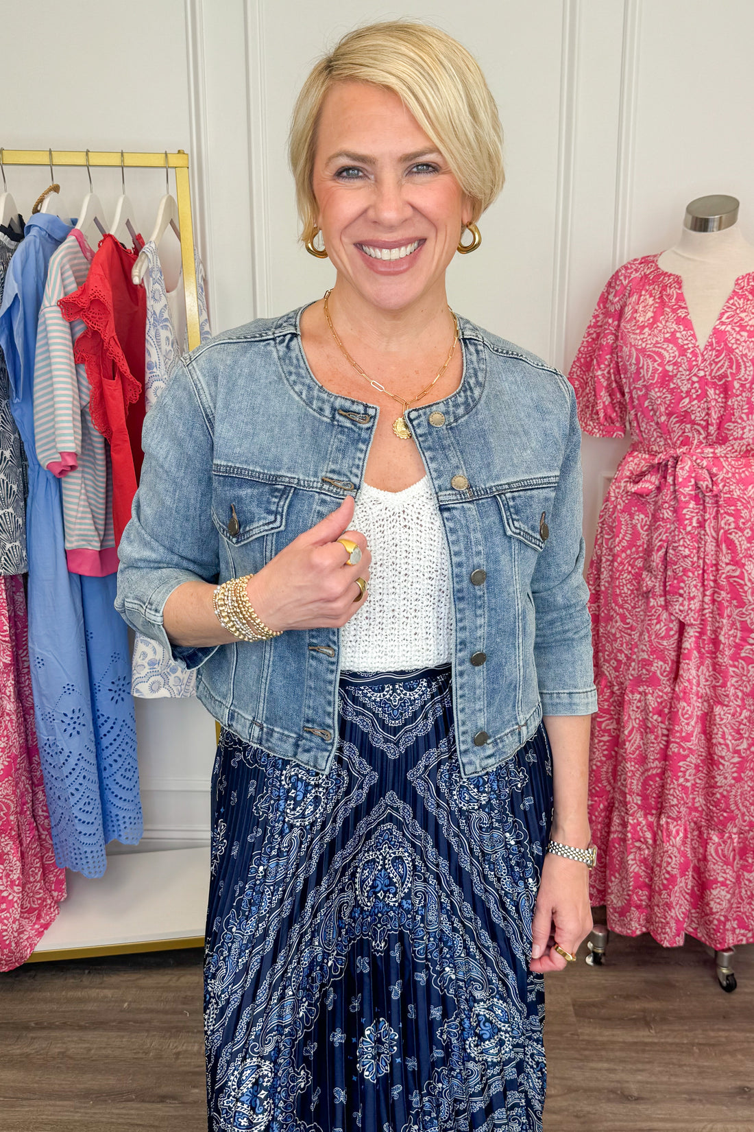 Front view of woman wearing Medium Wash Collarless Denim Jacket by Just Black Denim with top and skirt. 