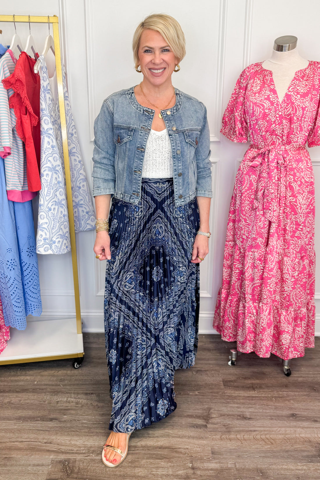 Front view of woman wearing Medium Wash Collarless Denim Jacket by Just Black Denim with top and skirt. 