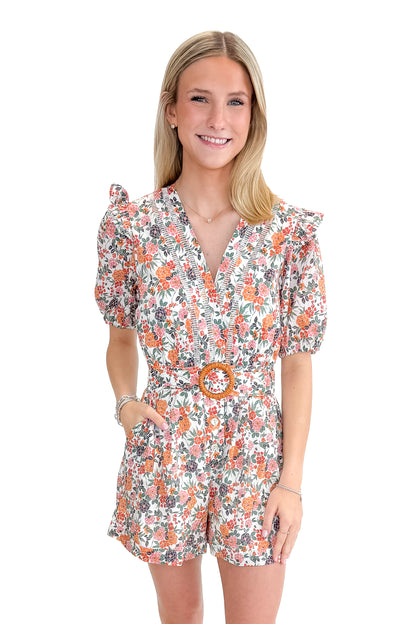 Front view of woman wearing Orange Floral &amp; Lace Romper With Belt against white studio background.