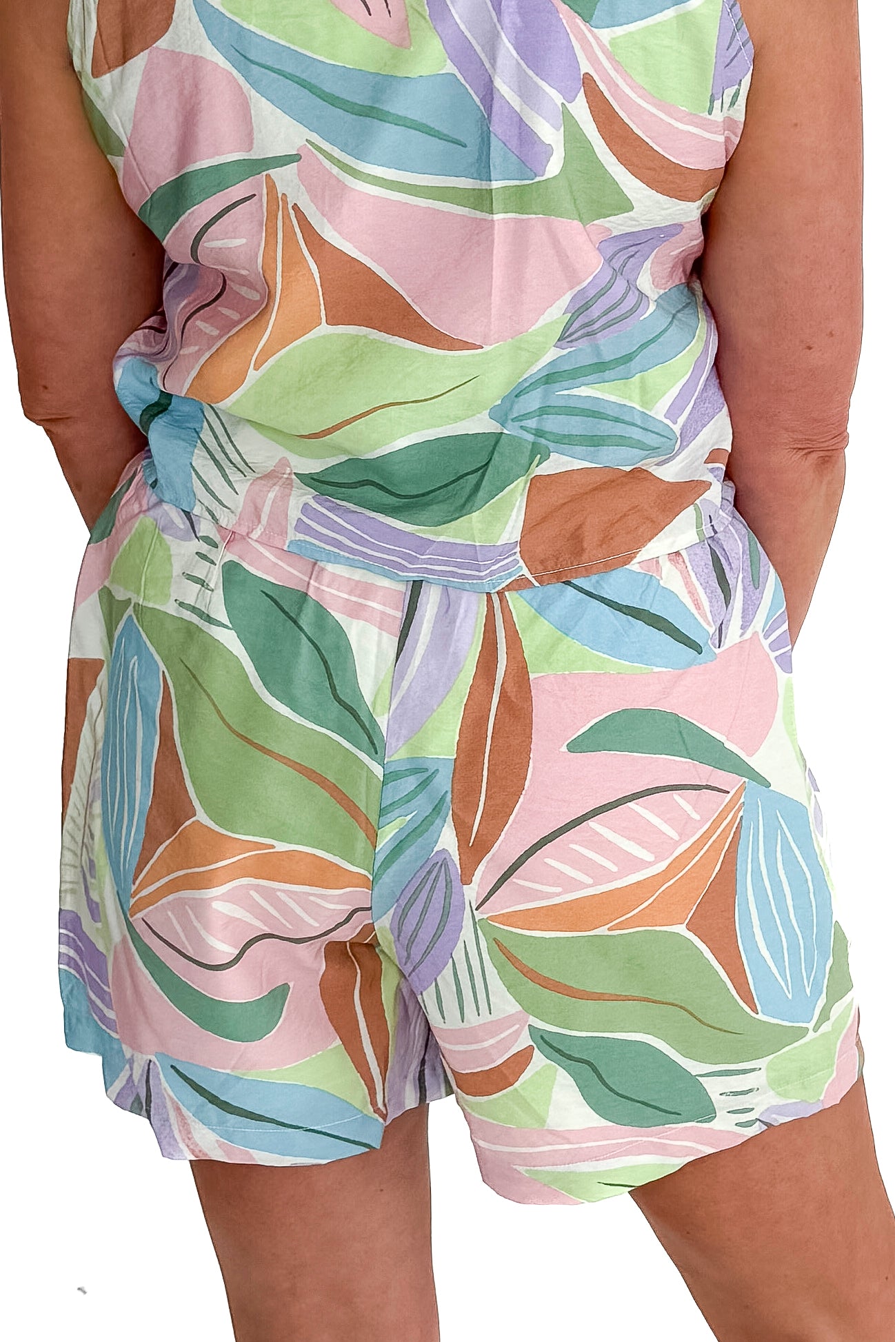 Back detail view of woman wearing Multi Leaf Print Shorts with matching tank against white studio background.