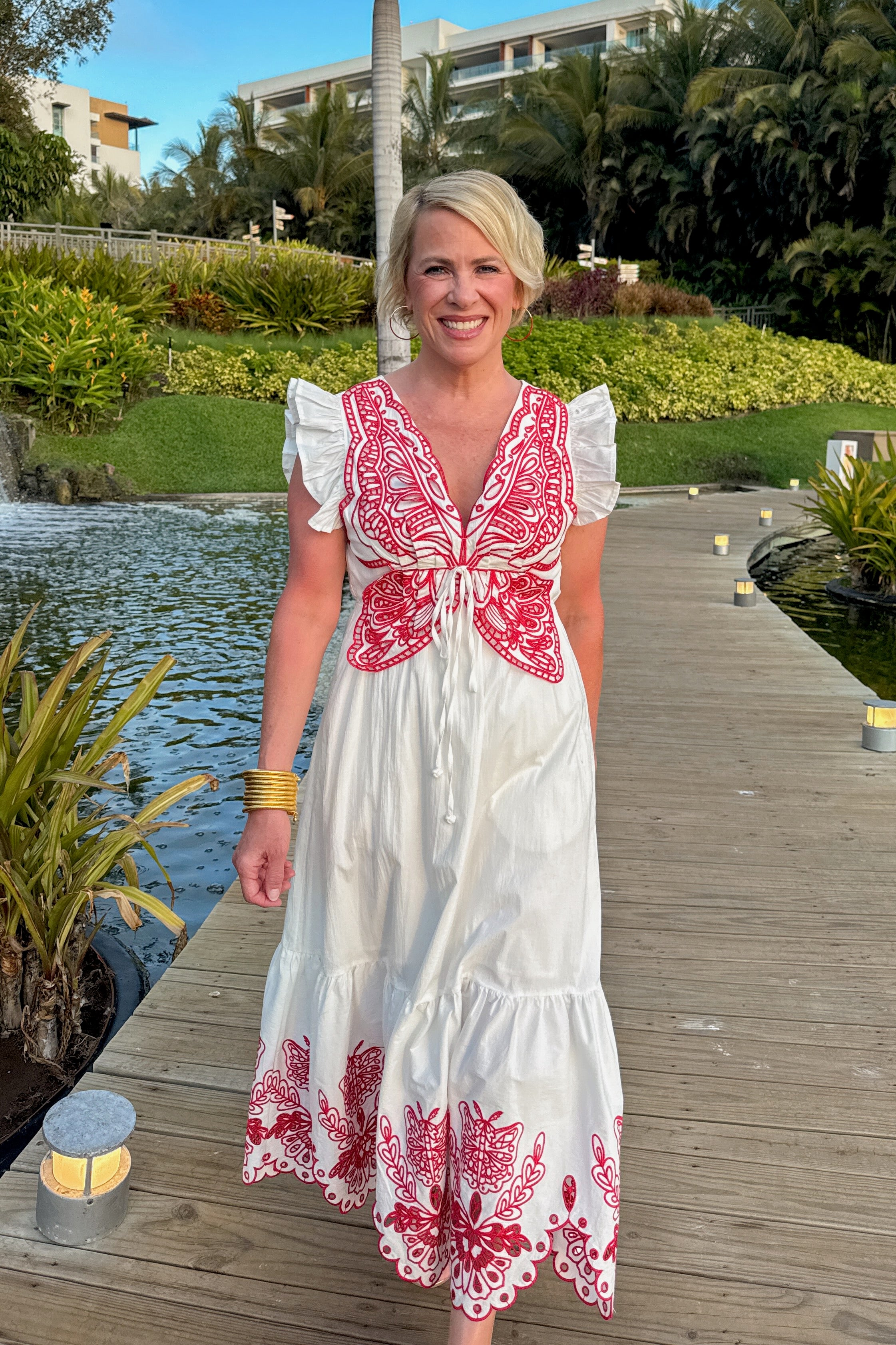 Front view of woman wearing Red &amp; White Butterfly Embroidered Midi Dress by Fate walking outside on a dock.
