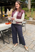 Women outside pouring drink wearing Plum Faux Leather Vest by Elan and jeans. 