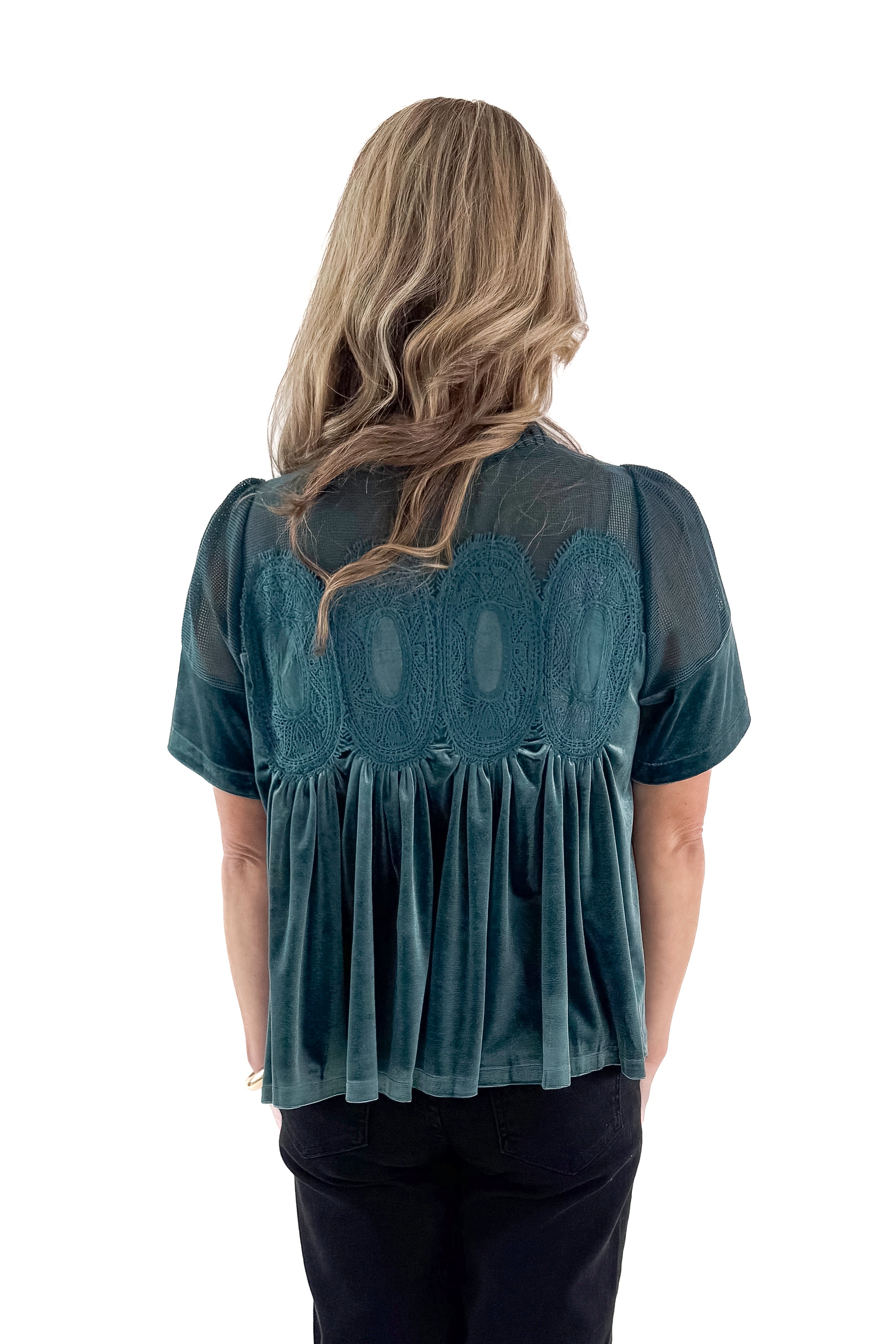 Back view of woman wearing Teal Velvet With Lace Applique Top with jeans against white studio background.