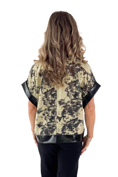 Back view of woman wearing Black &amp; Gold Metallic Abstract Print Top with jeans against white studio background.