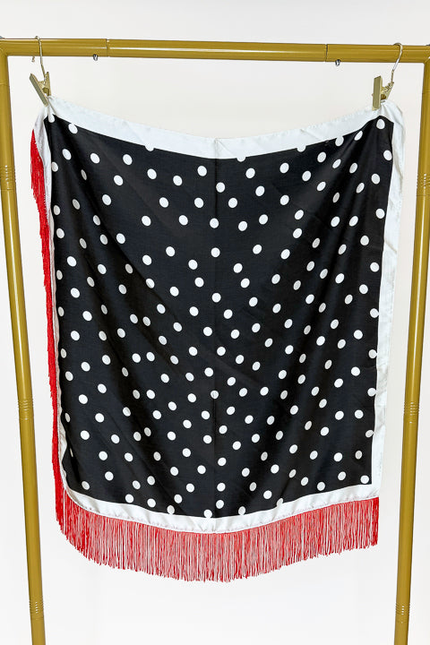 Fringe Detail Black With Polka Dots Square Scarf hanging on a rack.