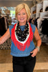 A smiling blonde woman wearing a blue denim vest and a black polka-dot scarf with bright red fringe, standing inside a clothing store.