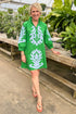 Woman wearing a green dress with sandals at a garden center.