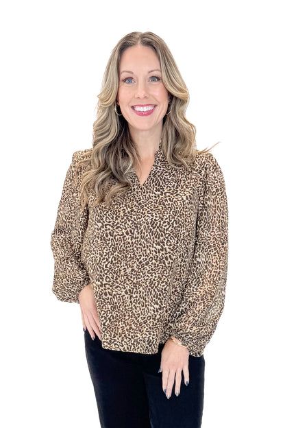 Front view of woman wearing Leopard V-neck With Metallic Detail Top with jeans against white studio background.