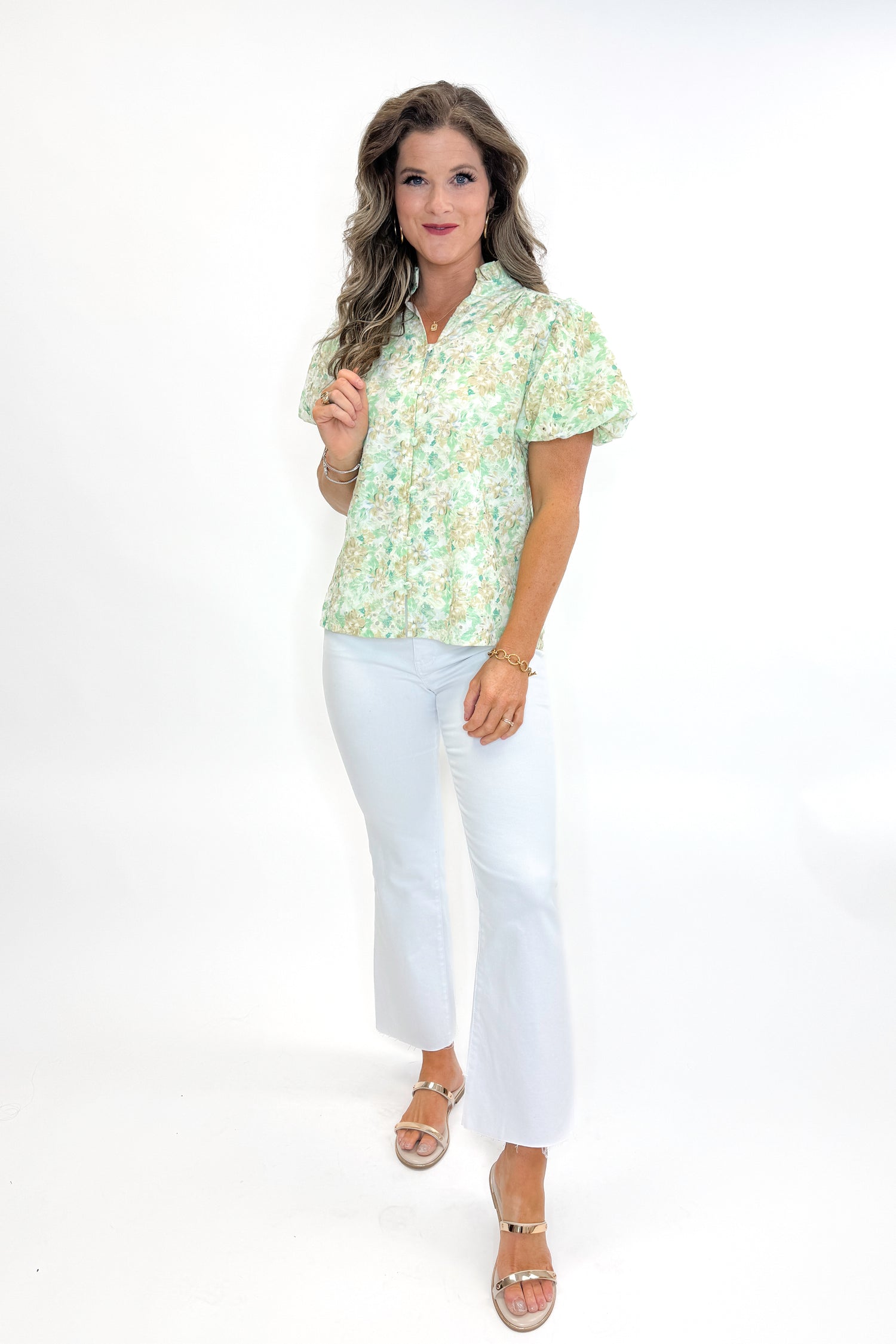 Front view of woman wearing Green &amp; Yellow Floral Eyelet Top with white jeans against white studio background.