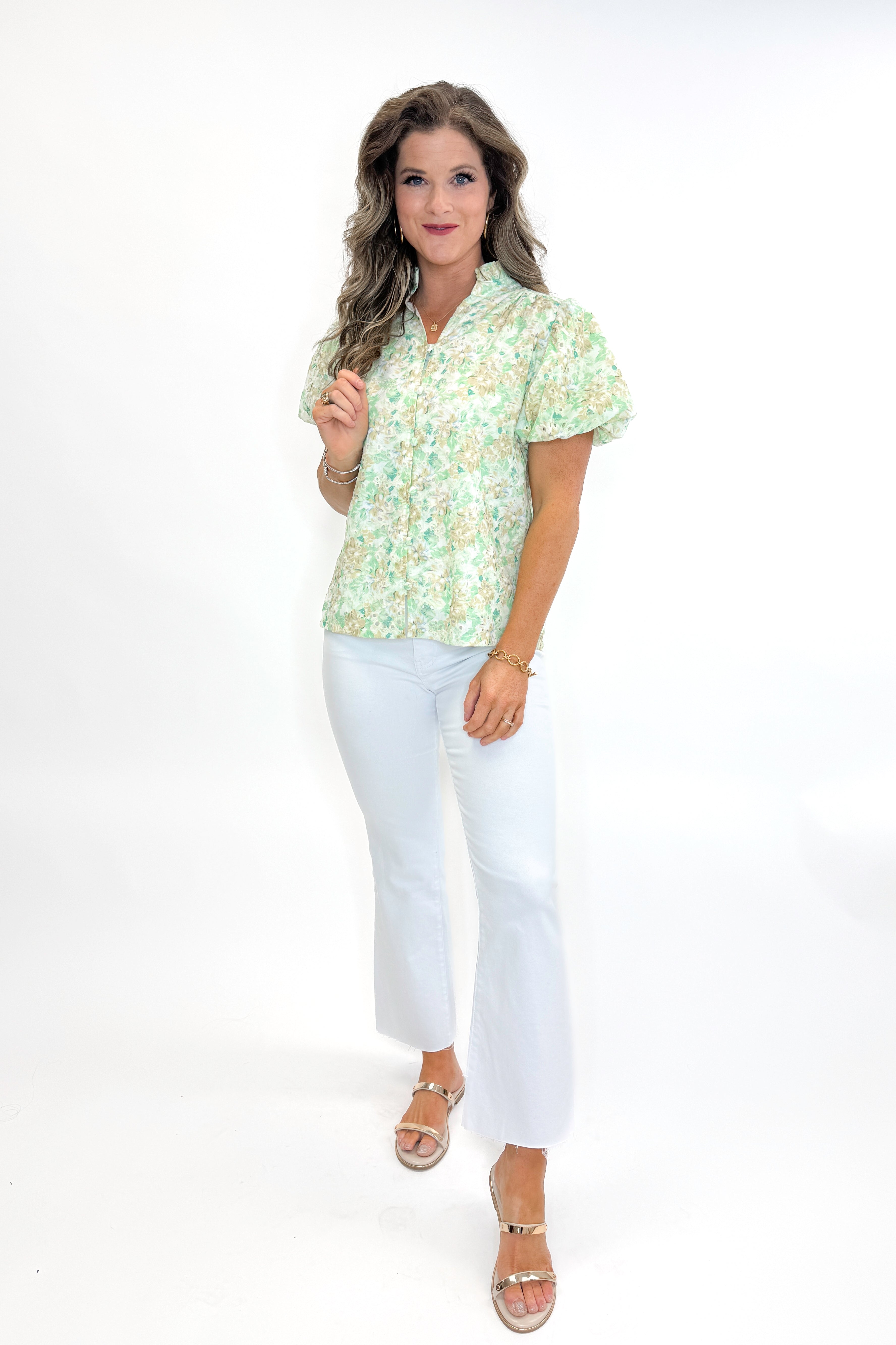 Front view of woman wearing Green &amp; Yellow Floral Eyelet Top with white jeans against white studio background.