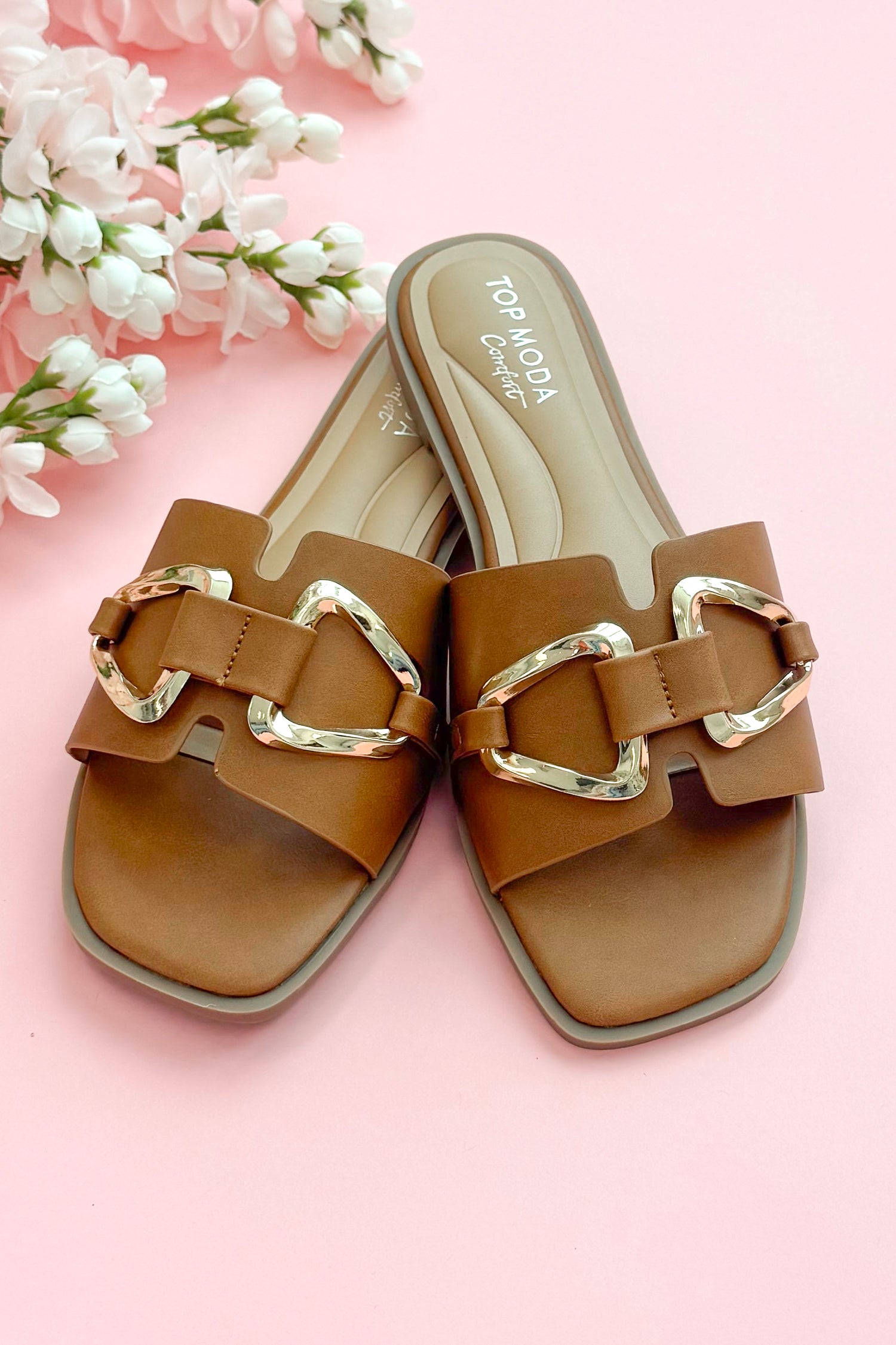Front view of Gelato- Tan Buckle Detail Sandals against pink studio background.