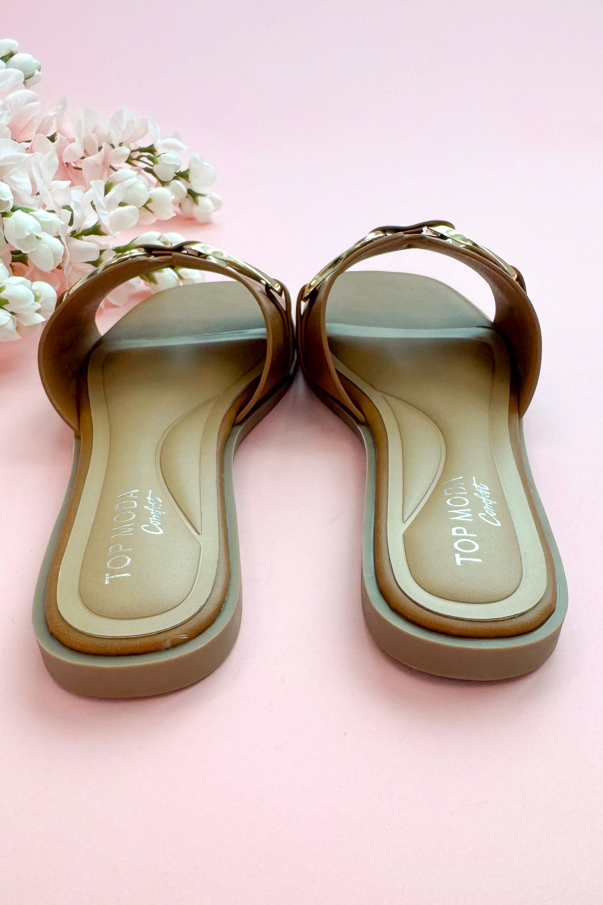 Back view of Gelato- Tan Buckle Detail Sandals against pink studio background.