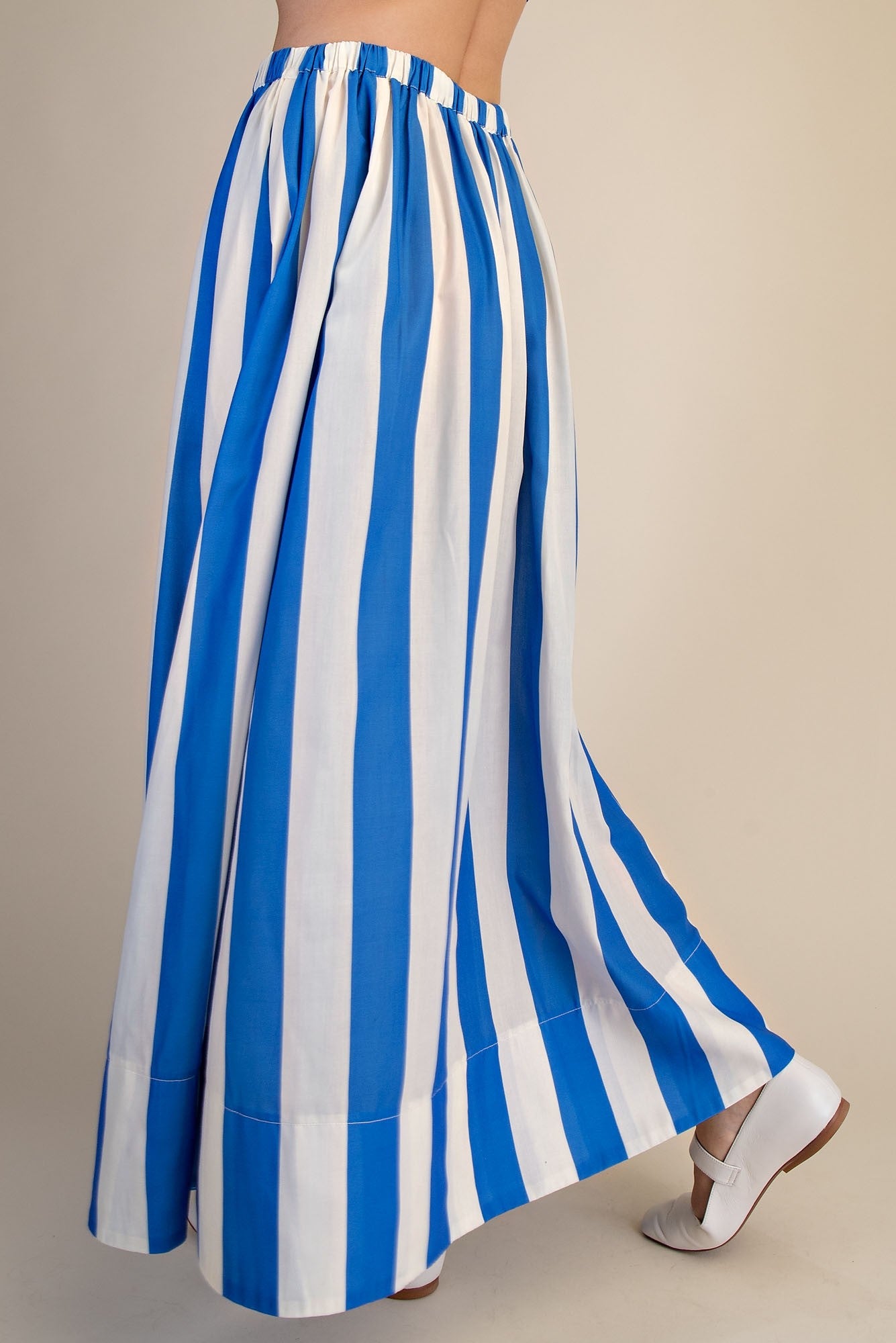 Back view of woman wearing Blue &amp; White Striped Skirt against studio background.