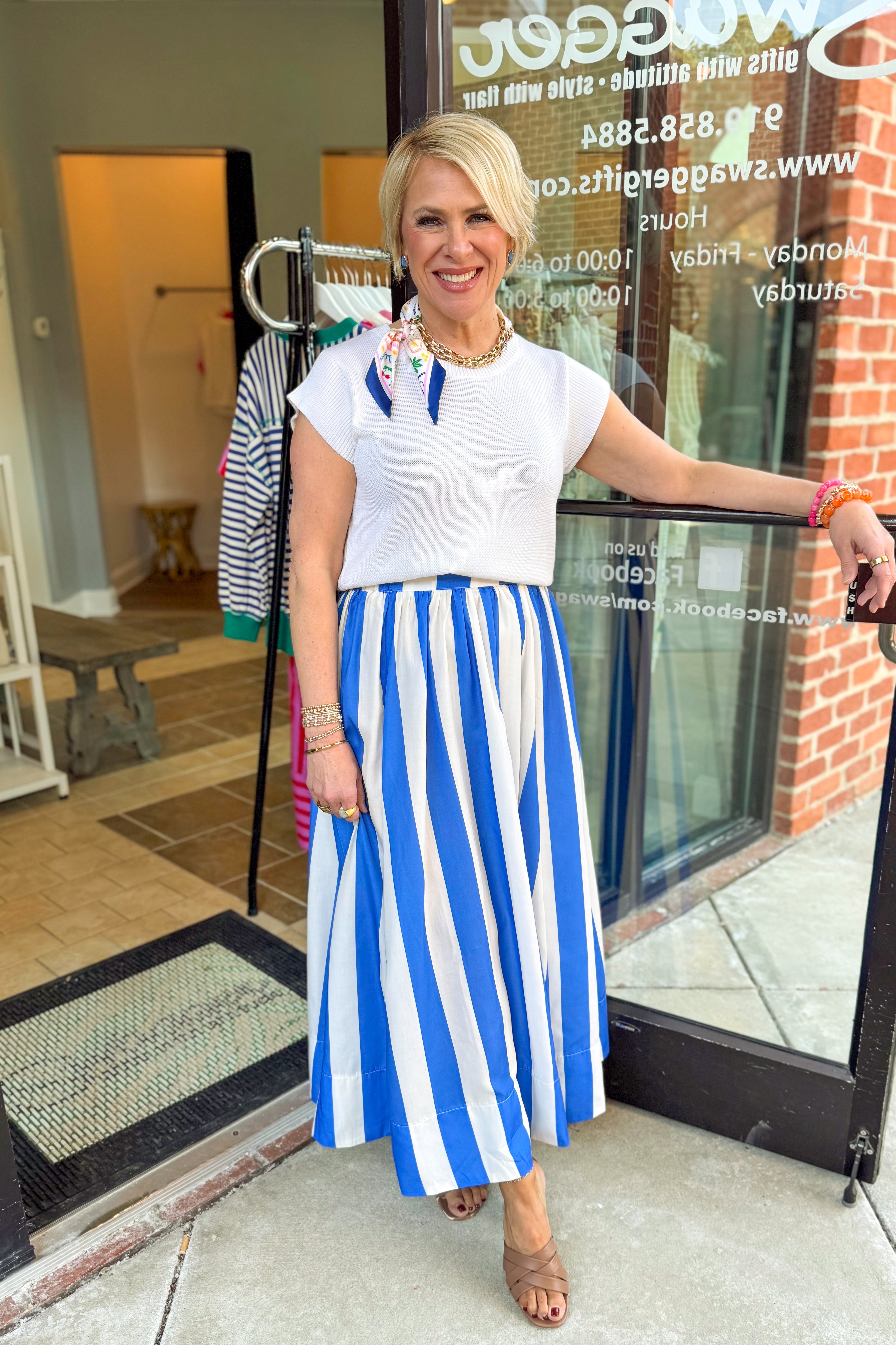 Front view of woman wearing Blue &amp; White Striped Skirt with sweater at Swagger Boutique.
