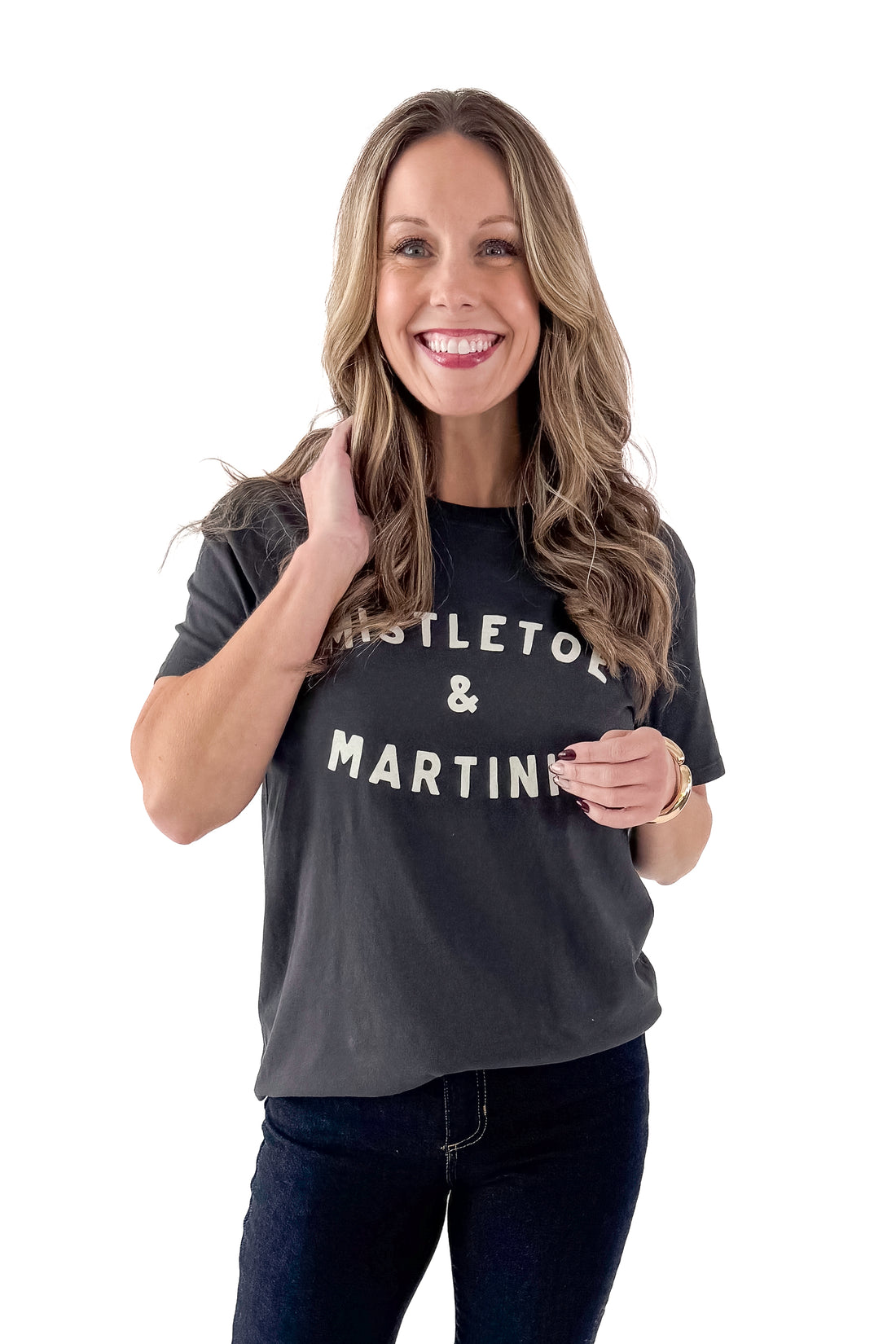 Front view of woman wearing Mistletoe Z Supply tee with jeans against white studio background.