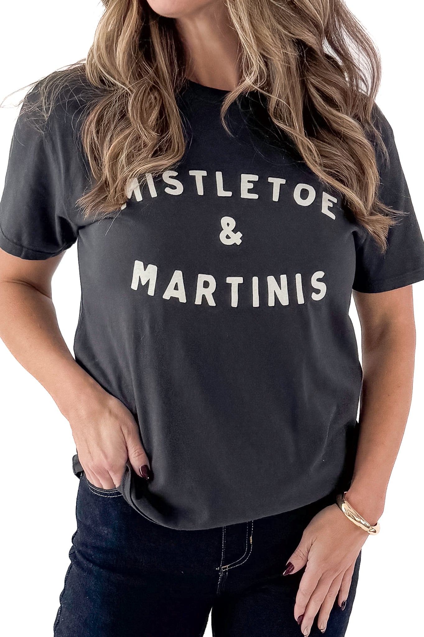Front detail view of woman wearing Mistletoe Z Supply tee with jeans against white studio background.