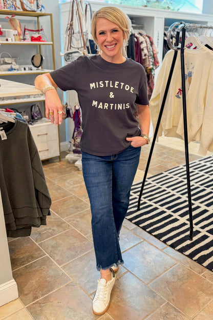 Front view of woman wearing Mistletoe Z Supply tee with jeans at a boutique.