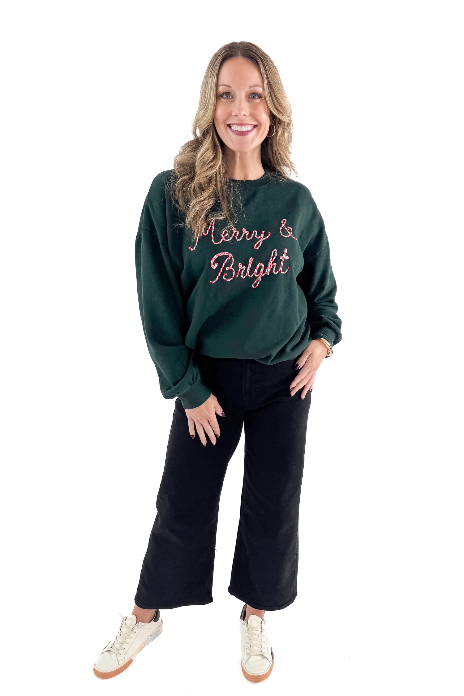 Front view of woman wearing Garland Green Bright Sunday Sweatshirt with jeans against white studio background.