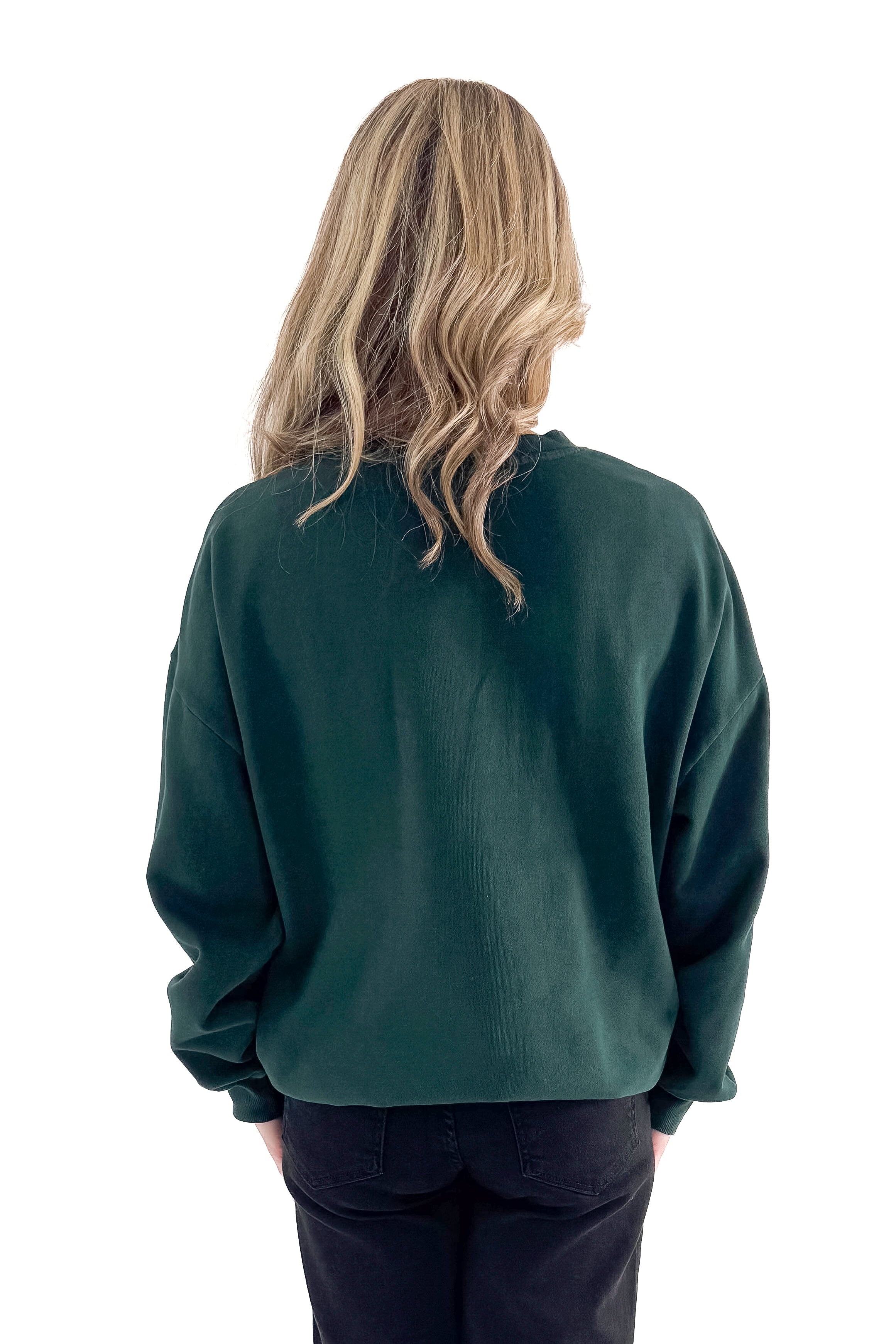 Back view of woman wearing Garland Green Bright Sunday Sweatshirt with jeans against white studio background.
