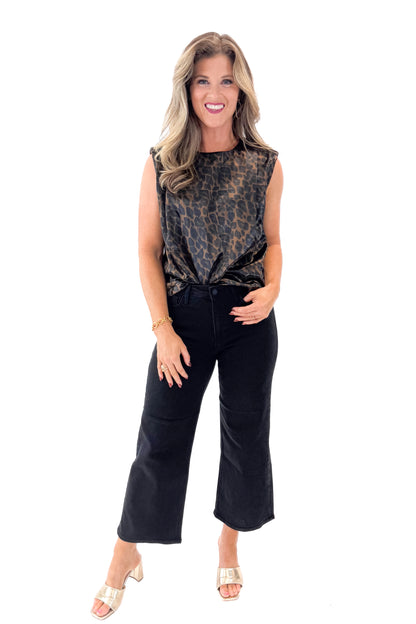 Front view of woman wearing Leopard Satin Sleeveless Top with jeans against white studio background.