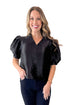 Front view of woman wearing Black Sheen Textured Puff Sleeve Top with jeans against white studio background.