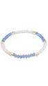 A beaded stretch bracelet featuring light blue faceted beads, opaque white beads, and shiny gold spacer beads, displayed on a clean white background.