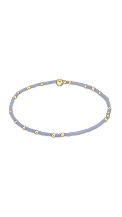 A light blue beaded bracelet with small gold spacer beads and a gold magnetic clasp, shown on a plain white background.