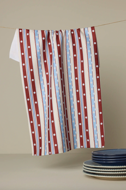 Red, white, and blue striped towel with white polka dots on a beige background