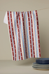 Red, white, and blue striped towel with white polka dots on a beige background