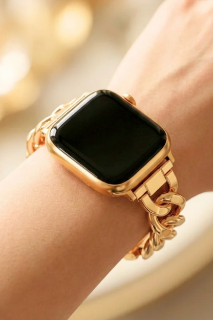 A close-up of a gold-toned smartwatch with a thick rectangular black screen and a chunky chain-link bracelet band worn on a person&