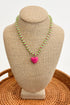 Necklace with a pink heart pendant on a beige bust against a white background