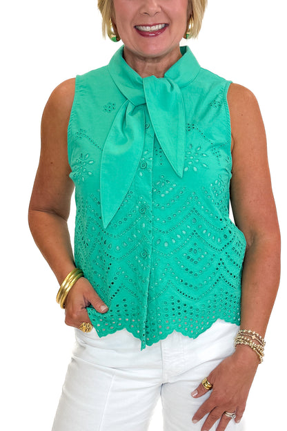 Front detail view of woman wearing Swagger Boutique’s Green Tie Neck Eyelet Sleeveless Top with jeans against white studio background.