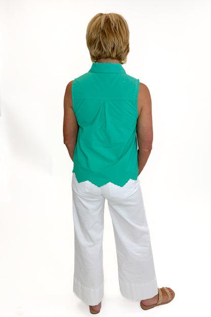 Back view of woman wearing Swagger Boutique’s Green Tie Neck Eyelet Sleeveless Top with jeans against white studio background.