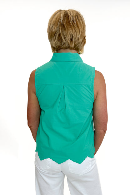 Back view of woman wearing Swagger Boutique’s Green Tie Neck Eyelet Sleeveless Top with jeans against white studio background.
