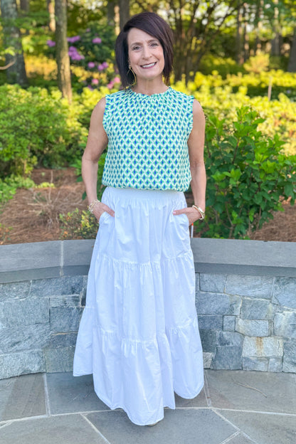 Woman wearing Green &amp; Blue Abstract Printed Tank with white skirt standing outside.