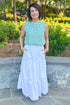 Woman wearing Green & Blue Abstract Printed Tank with white skirt standing outside.