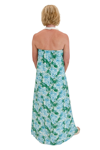 Back view of woman wearing Swagger Boutique’s Green &amp; Blue Floral Print Strapless Maxi Dress by Entro with sandals against white studio background.