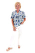 Front view of woman wearing Swagger Boutique’s Green & Blue Floral V-Neck Top with sandals against white studio background.