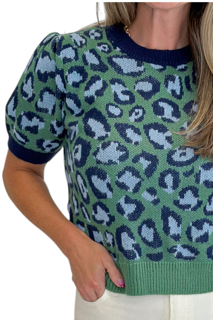 Front detail view of woman wearing Swagger Boutique’s Green &amp; Blue Leopard Short Sleeve Sweater with jeans against white studio background.