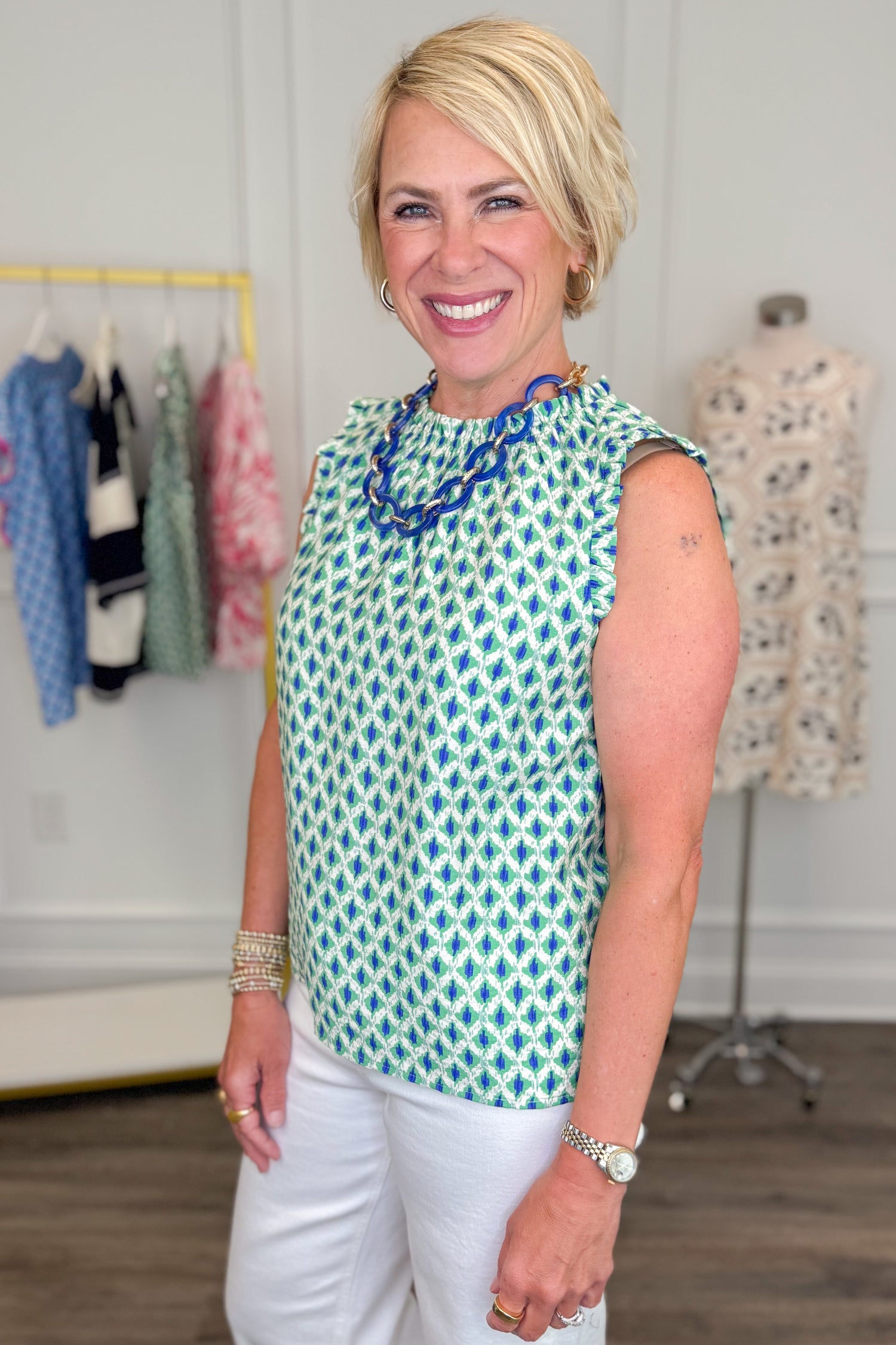 Woman wearing Green &amp; Blue Abstract Printed Tank top in a clothing store setting