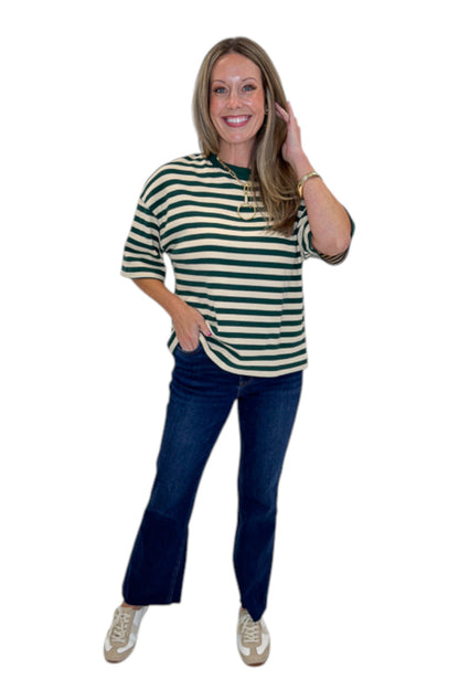 Front view of woman wearing Swagger Boutique’s Green &amp; Cream Striped Textured Tee by Entro with jeans against white studio background.